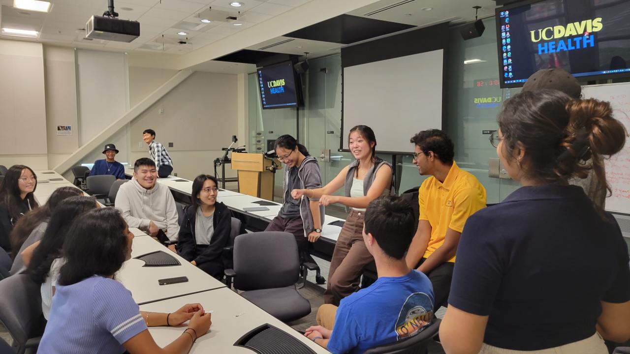 A small group of undergraduate students talk in a classroom during the fall quarter of 2023. They were the first to participate in a redesigned biomedical engineering experience that blends immersive clinical opportunities with classes on physiology, entrepreneurship and engineering design. (Courtesy of Xianglong Wang)