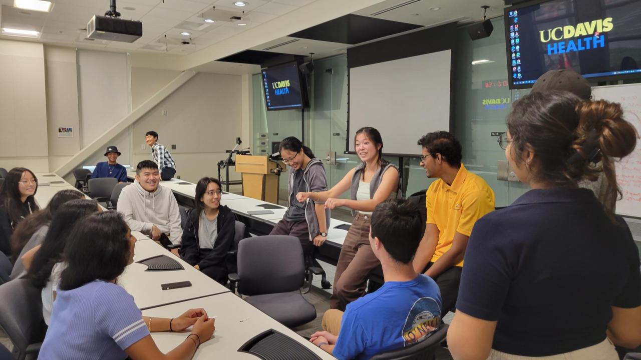 A small group of undergraduate students talk in a classroom during the fall quarter of 2023. They were the first to participate in a redesigned biomedical engineering experience that blends immersive clinical opportunities with classes on physiology, entrepreneurship and engineering design. (Courtesy of Xianglong Wang)