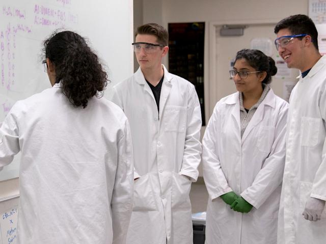 undergraduates in lab coats in the bio design lab