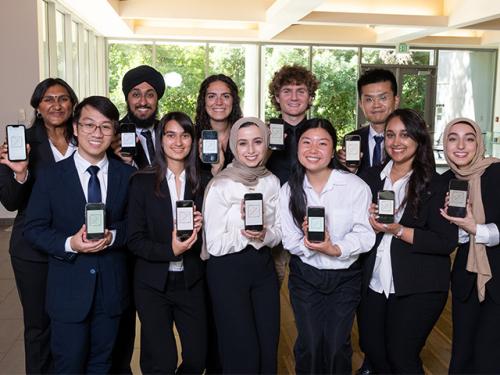 The entire BioChem ML team of 11 students display their smart phones with their app.