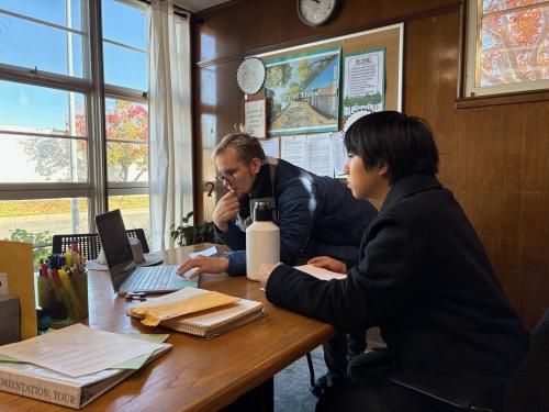 Seito Ezawa working on a project with Western Service Workers Association leadership in an office.