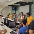 A small group of undergraduate students talk in a classroom during the fall quarter of 2023. They were the first to participate in a redesigned biomedical engineering experience that blends immersive clinical opportunities with classes on physiology, entrepreneurship and engineering design. (Courtesy of Xianglong Wang)